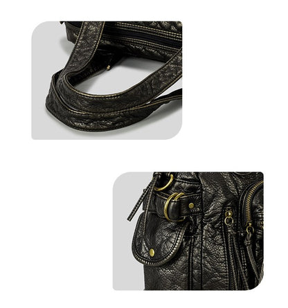 Close-up of a black leather handbag with gold hardware on a white background